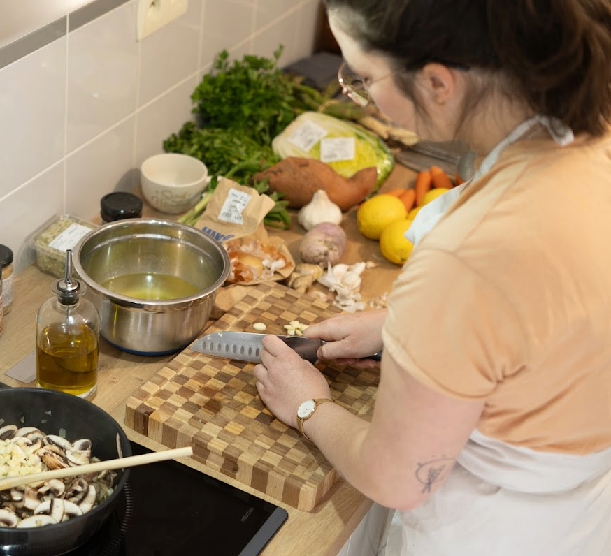Clara, cheffe à domicile, prépare des plats végétaux pour la semaine dans la cuisine d'un client à Montpellier